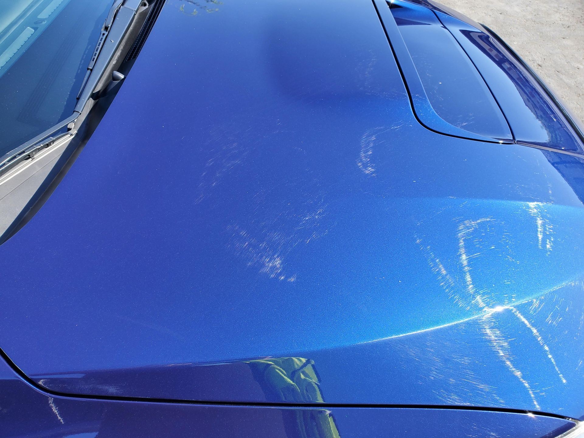 Swirl marks shown from damage done by an automatic car wash by bristle brushes.